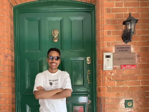 Ajamu Brown Standing in front of a door