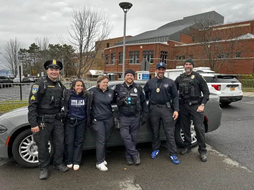 Image of Public Safety Officers posed in front of car.