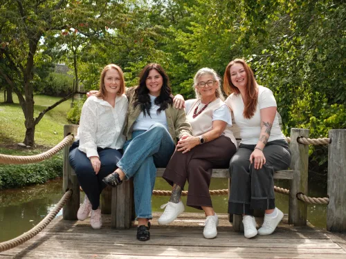 Image of ICare and Student Support Team seated on bench at Muller Pond. Left to right: Rebecca Cogan Carroll, Emmy LoBrutto, Joelle Albertsman, Danni Klein.