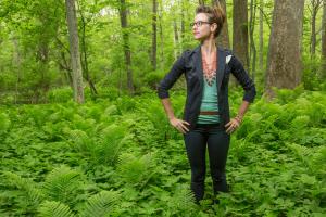 Sarah Brylinsky stands in a lush green forest