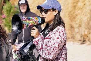 Alumna Aya Tanamura directing on an outdoor film set. 