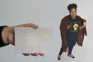 A hand holds a business card that reads "Malaika Apparel," while a young woman poses in the background.