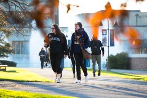 Students walk across campus during autumn.