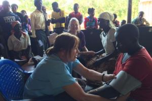 Mary Taylor taking a young man's blood pressure in Malawi.