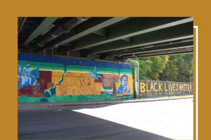 A picture of an underpass with a mural on the far side wall.  The mural has a picture of Fredrick Douglass as well as the words "Black Lives Matter"