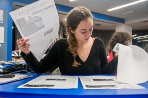 Student looks over printed newspaper proofs.