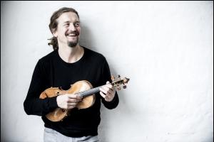 Violinist Christian Tetzlaff holds his instrument and smiles