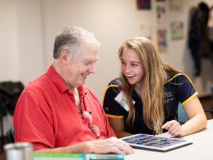 student helping older person