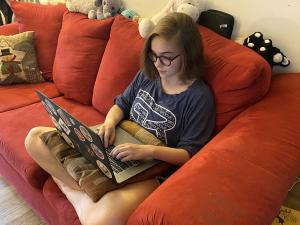 a student on a laptop on a couch