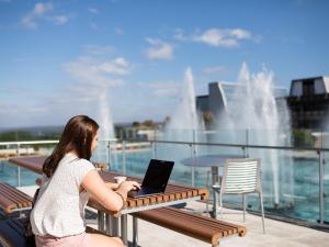 student on a laptop by the fountains