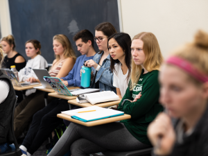 Students sitting at their desks in a classroom facing forward during a lecture