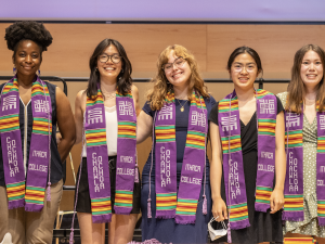 students smiling with a purple stole 