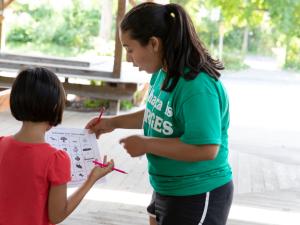 A student works with a young child on a scavenger hunt.