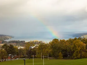 A rainbow appears in an autumn skyline. 