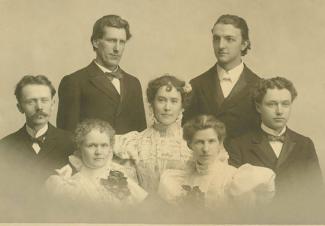 Black-and-white portrait of seven people. 