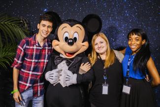 Alumni pose with Mickey Mouse for photos