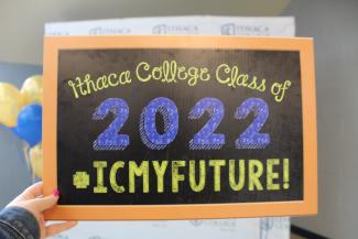 Handheld chalkboard that reads "Ithaca College Class of 2022 #icmyfututre!" 