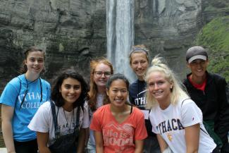 A group of young people in front of a waterfall