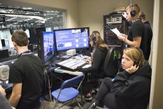 Students work behind the scenes at a symposium at Ithaca College