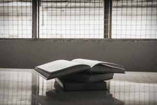 Books on a table in front of prison windows