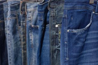 Several pairs of blue jeans up close