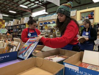 Students organizing books for the Friends of the Tompkins County Public Library