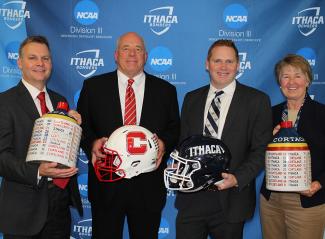 Athletic directors and football coaches from Ithaca College and Cortland State hold the Cortaca Jugs