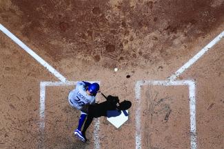 Baseball player hitting the ball from home plate from an aerial view