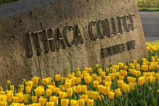 entrance sign to Ithaca College with tulips
