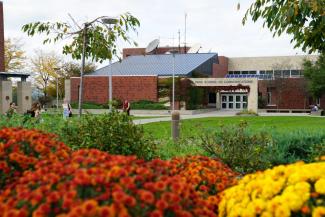 A college building with flowers in the foreground