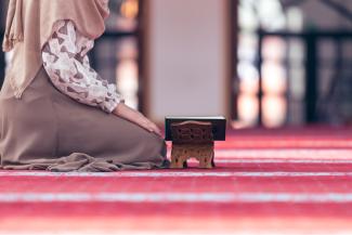 A woman kneeling in a mosque