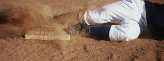 A baseball player sliding into base