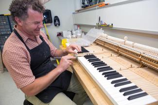 man repairing a piano