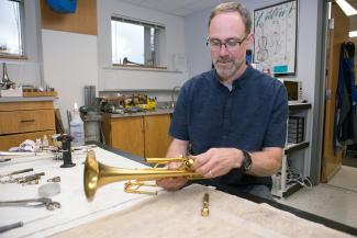 man repairing trumpet