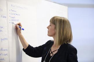 woman writing on a large sheet of paper