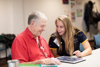 student helping an older person