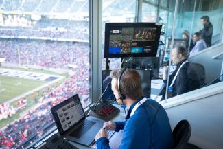 man watches football game from control room