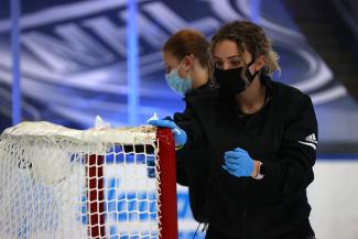 Ice crew member wiping down a goalpost