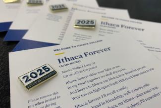 A picture of the class of 2025 pins and the words to the alma mater