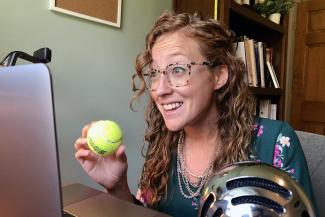 Colleen holds a ball while talking online.