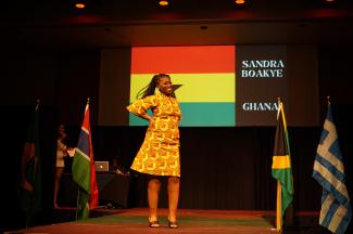 Student on the runway with the Ghanan flag behind them