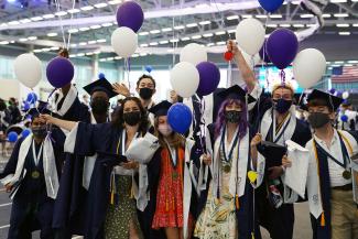students in regalia with balloons