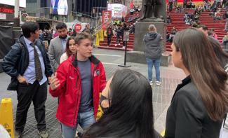 Students standing in Times Square with Alum Taylor Varga '17