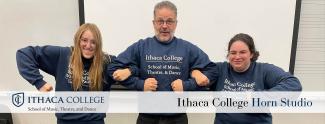 Three musicians smiling wearing matching sweatshirts reading "Ithaca College School of Music, Theatre, and Dance"