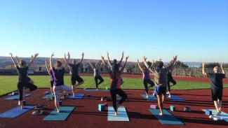 Outdoor yoga with group exercise instructor.