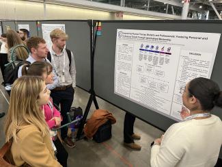 Students learn from a poster presenter at a national conference