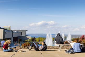 Ithaca College students overlooking fountains and Cayuga Lake