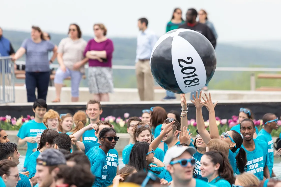 Students splash in a fountain and hit a beach ball in the year