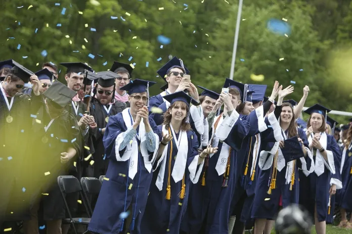 Graduates in robes watching confetti