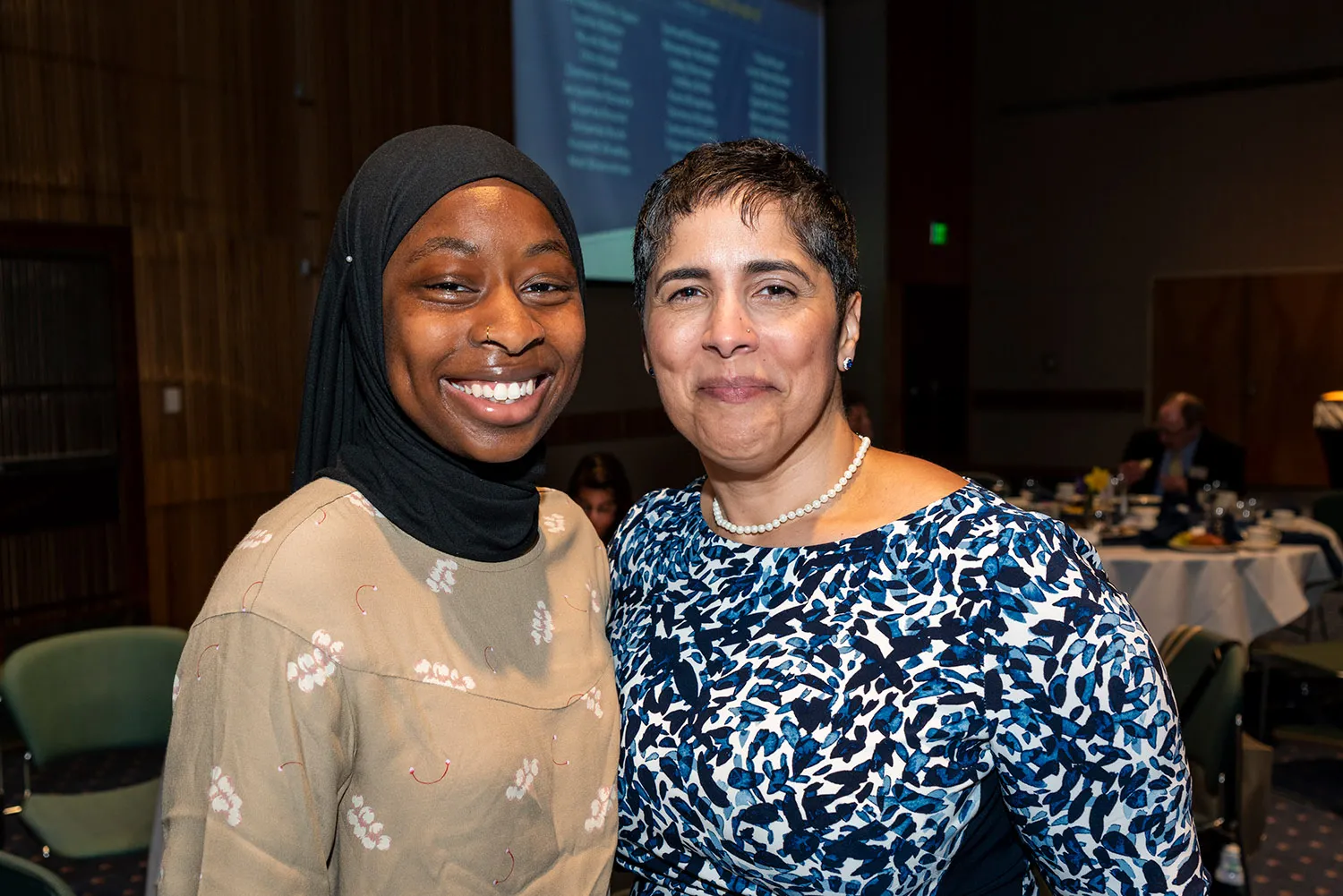 A student in a hijab posing with a woman